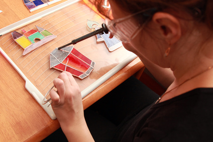 Stained glass maker works with colorful souvenirs