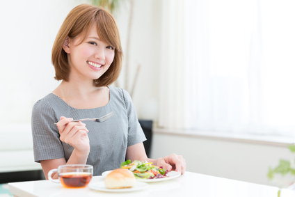 朝食にサラダを食べる女性