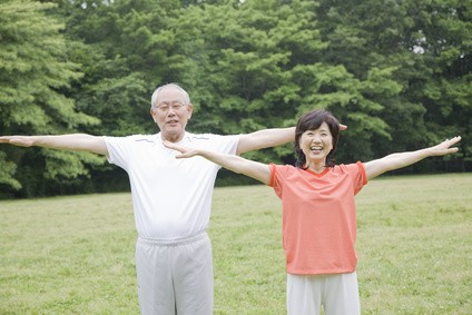 公園でラジオ体操をする老夫婦
