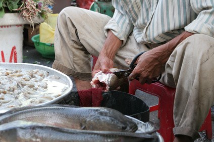 露店で魚を売るベトナムの人