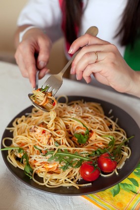 フォークとスプーンでパスタを食べる